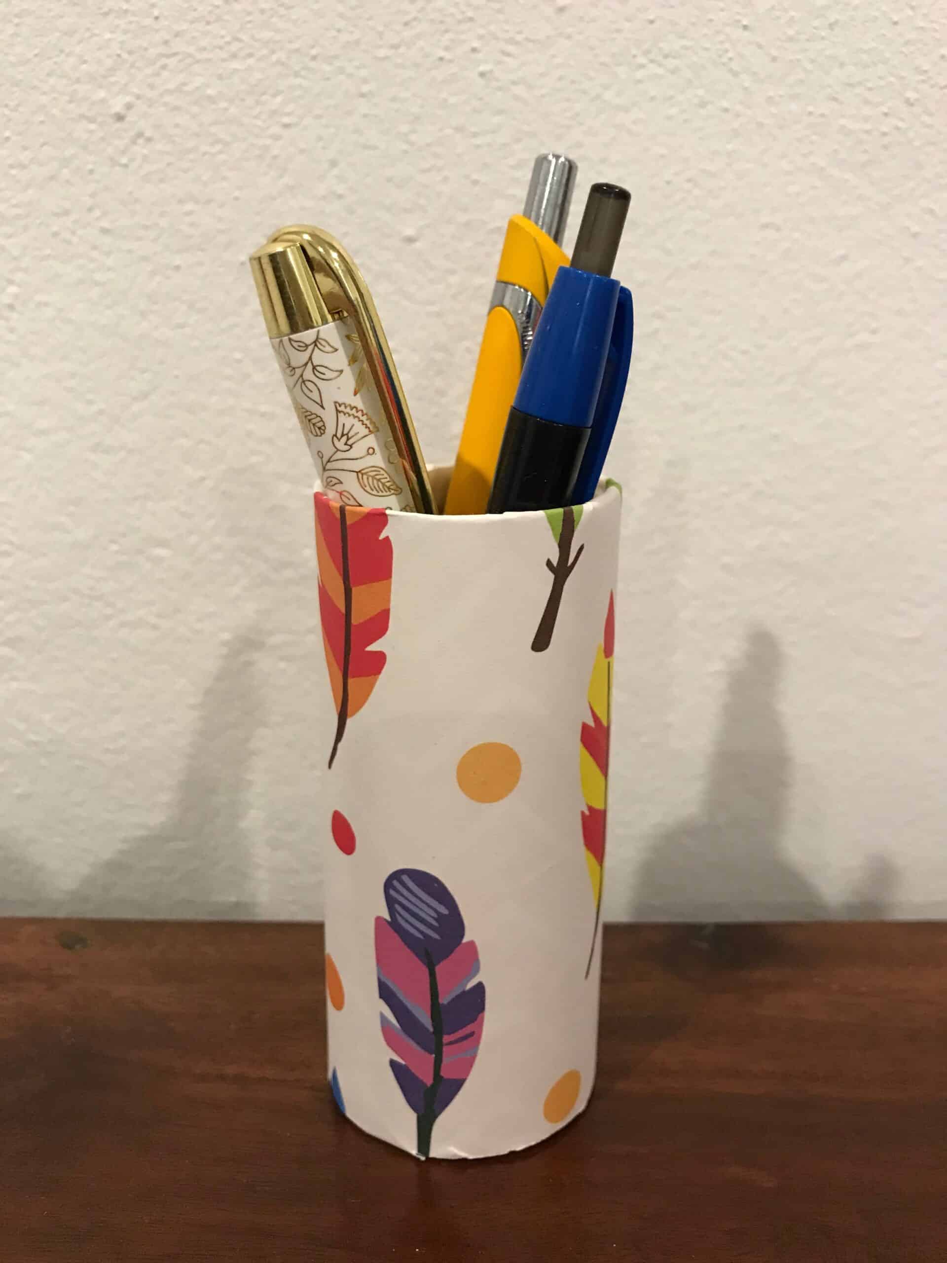 pens cheaply organized on a desk using toilet roll holder