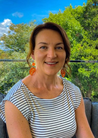 Christine smiling at the camera with trees blurred in the background